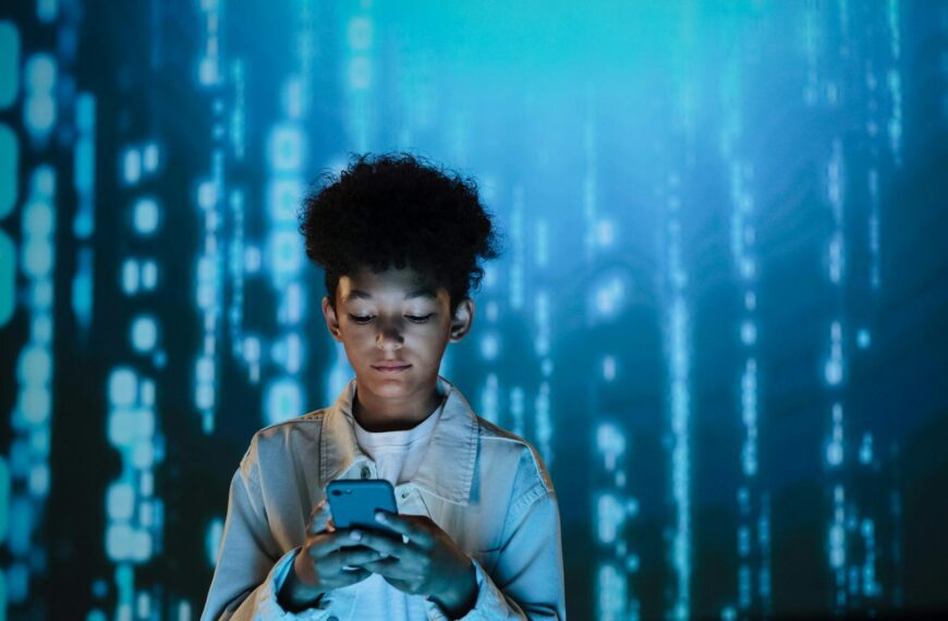 Curly-haired boy focused on smartphone amidst digital backdrop