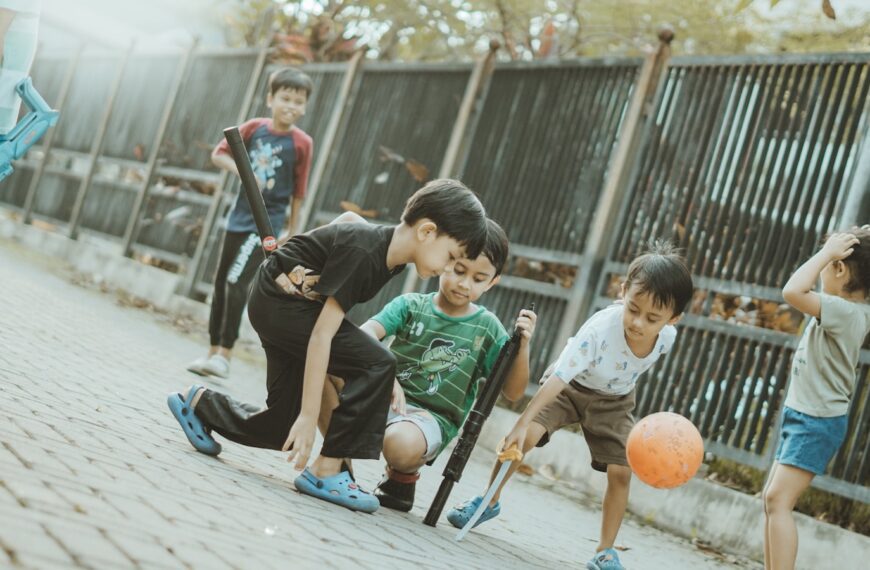 Children play together with a ball and sticks.