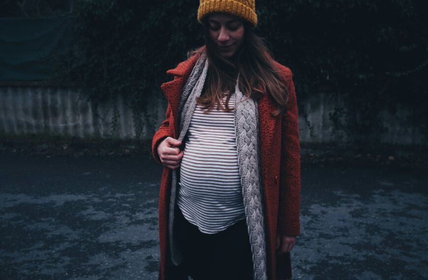 woman in red coat and black and white striped shirt