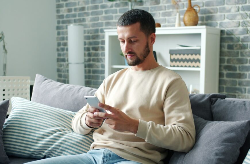 Man sitting on sofa using smartphone