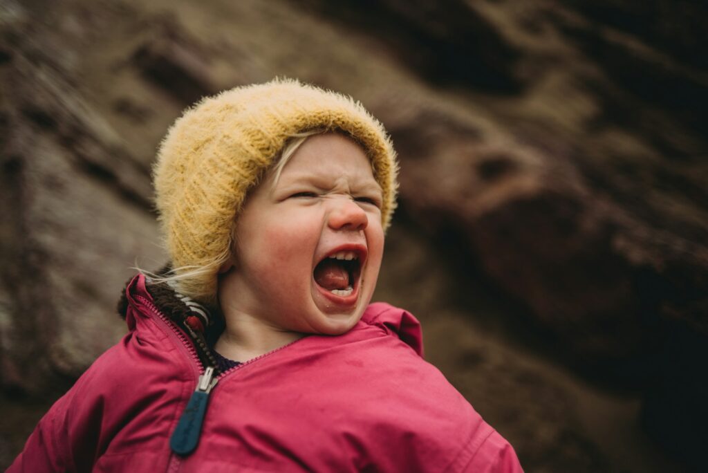 girl in pink zip up jacket and yellow knit cap