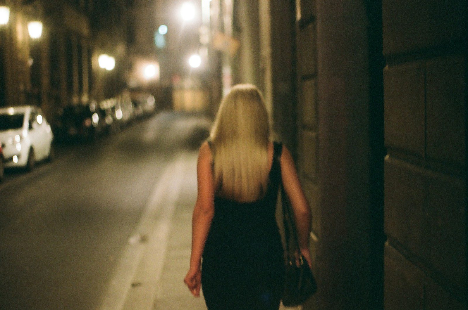 a woman walking down a street at night