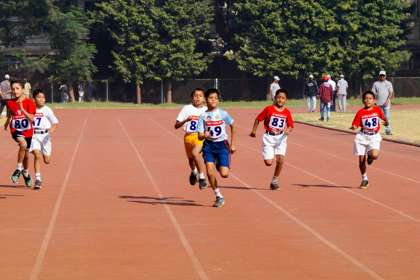 A group of young men running across a track