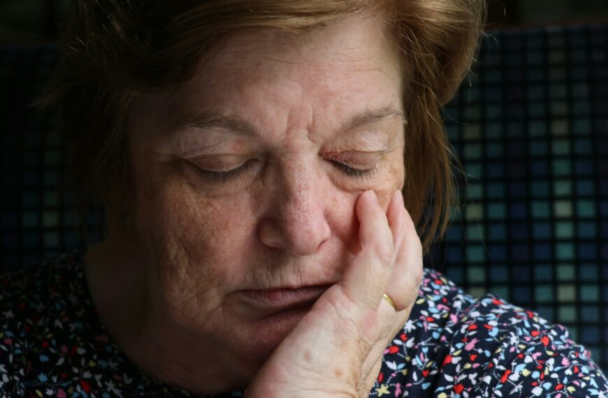Elderly woman with hand on her cheek
