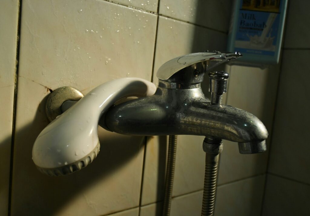 A faucet that is attached to a tiled wall