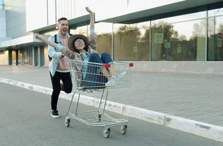 Couple having fun riding in a shopping cart