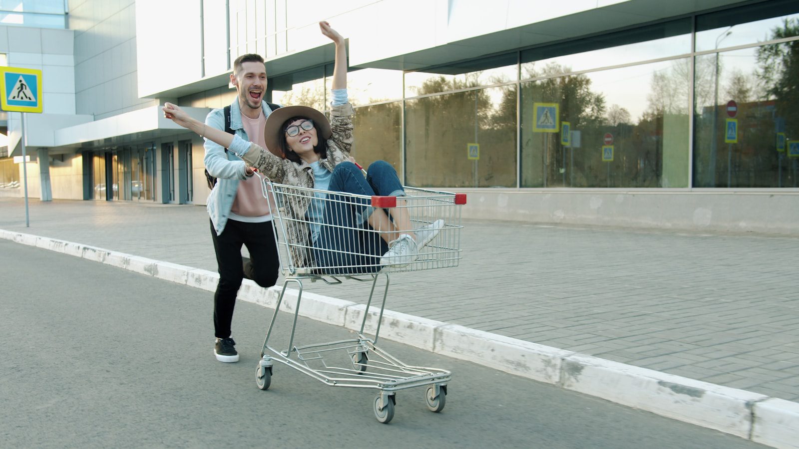 Couple having fun riding in a shopping cart