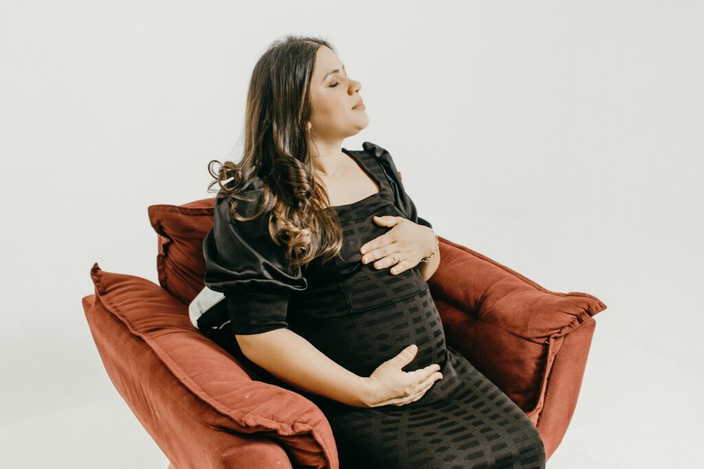 a pregnant woman sitting in a red chair