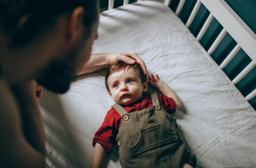 boy in red polo shirt lying on bed