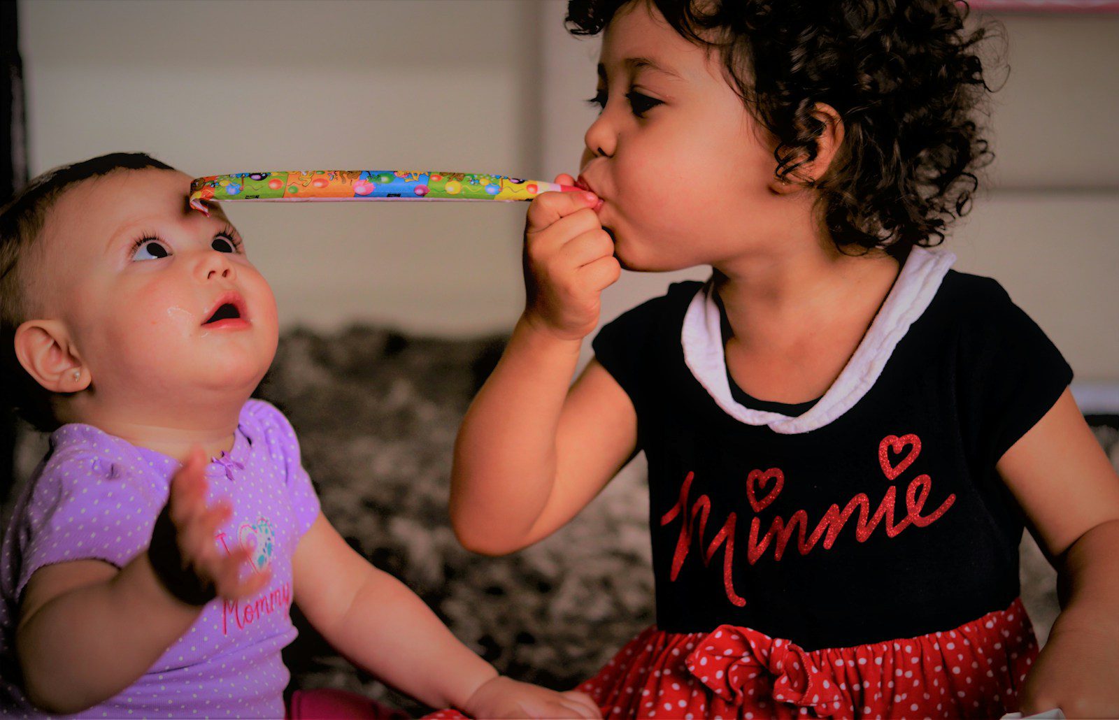 girl in black and red tank top holding pink and green paint brush