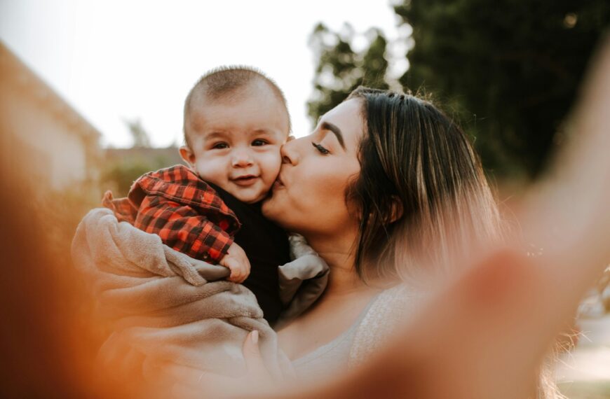 woman kiss a baby while taking picture
