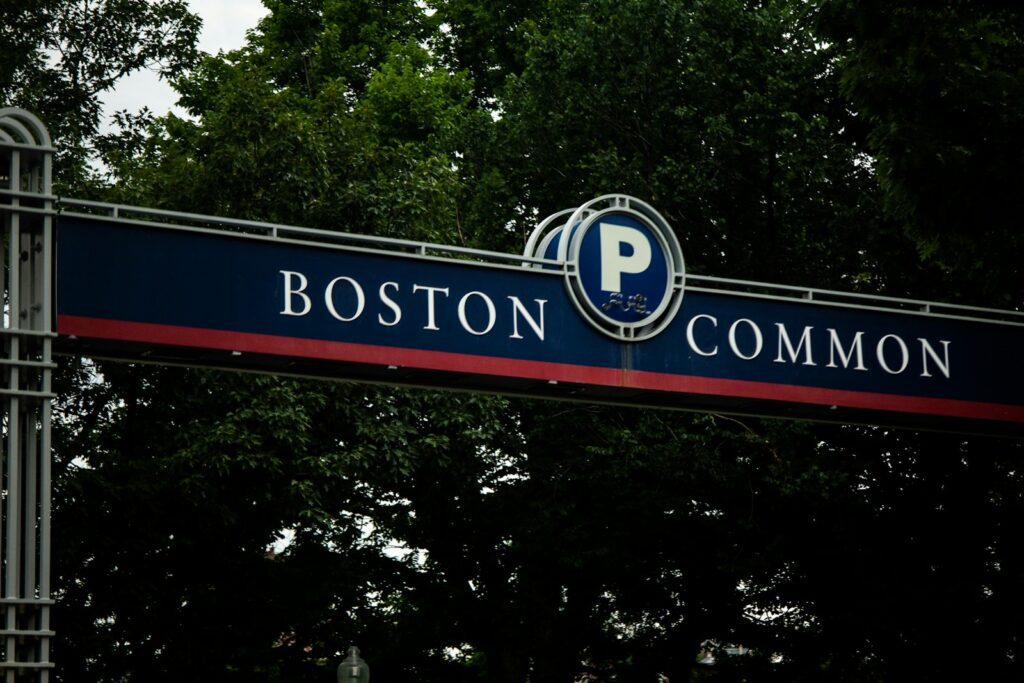 a street sign for boston common with trees in the background