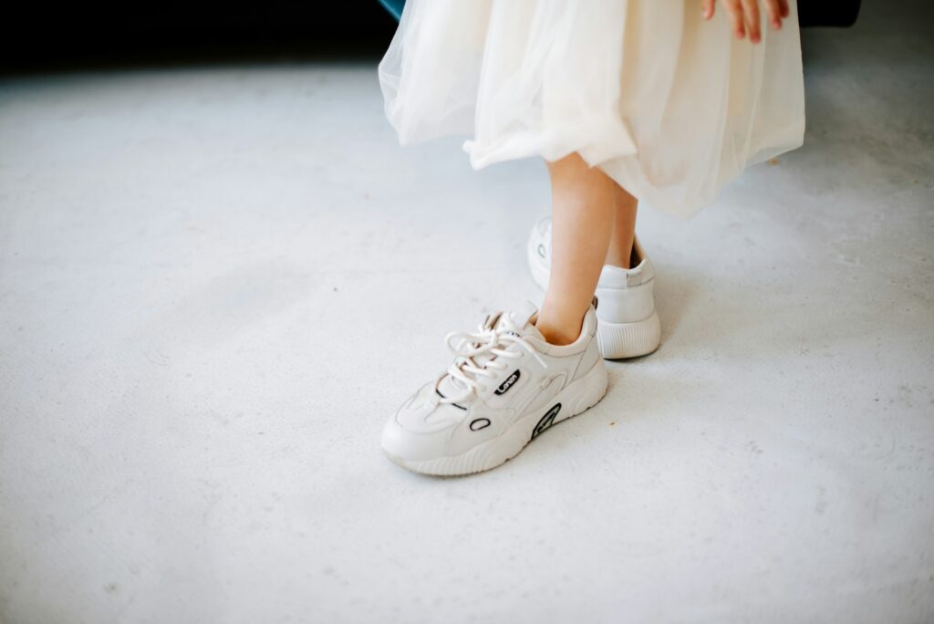 a close up of a person wearing white shoes