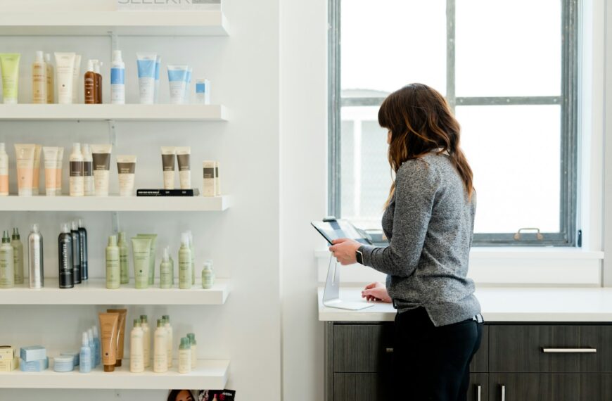 woman in gray sweater holding pen