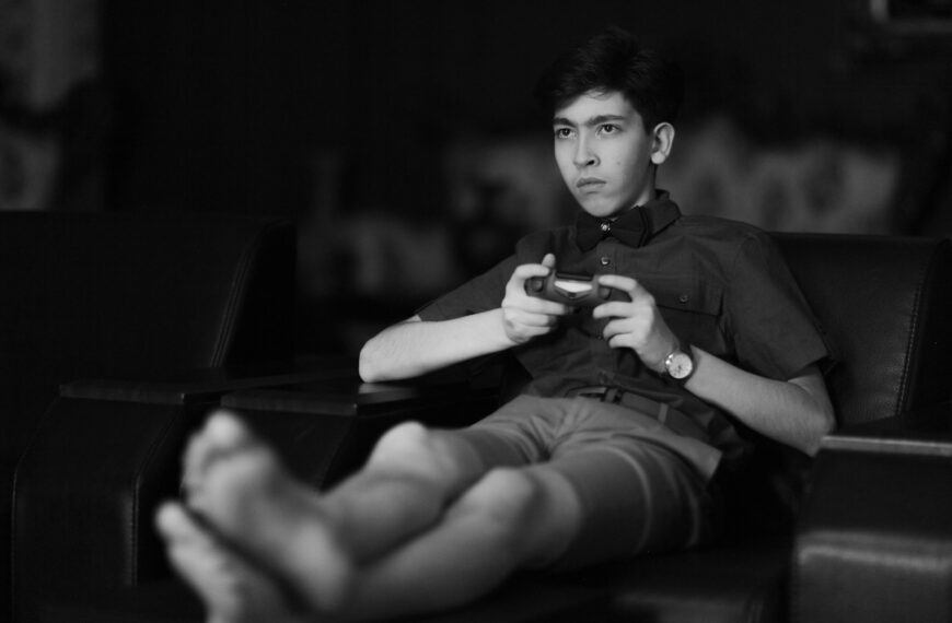 man in black button up shirt and black shorts sitting on chair