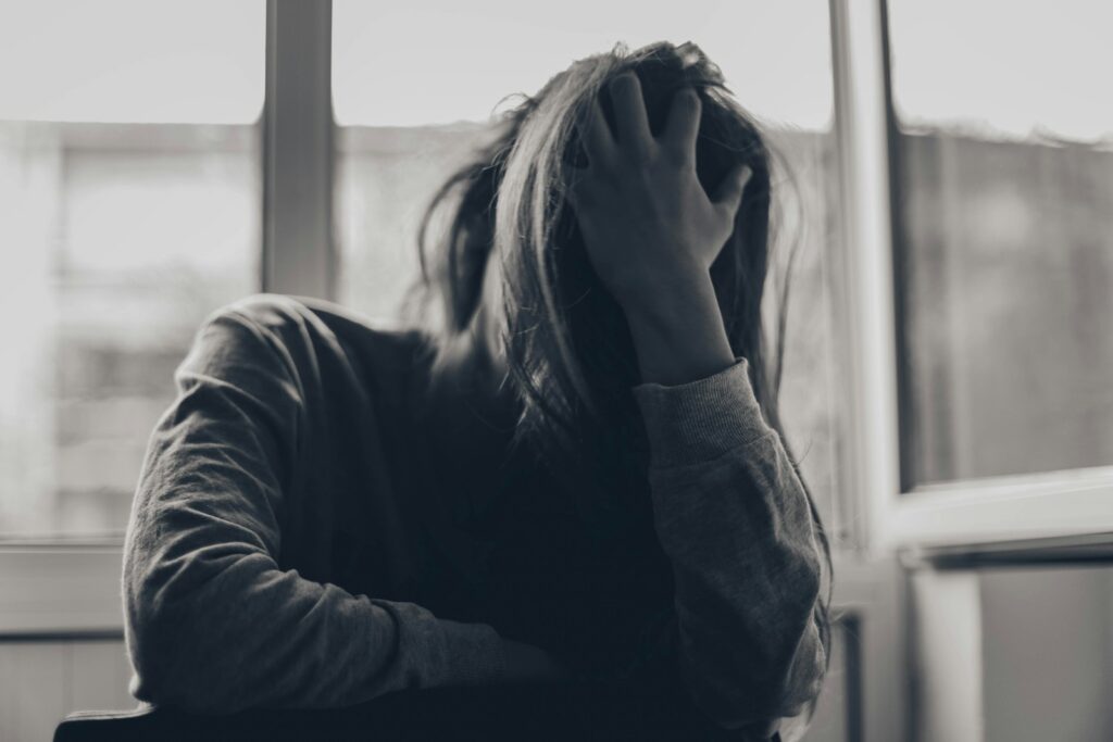 grayscale photography of person covering face