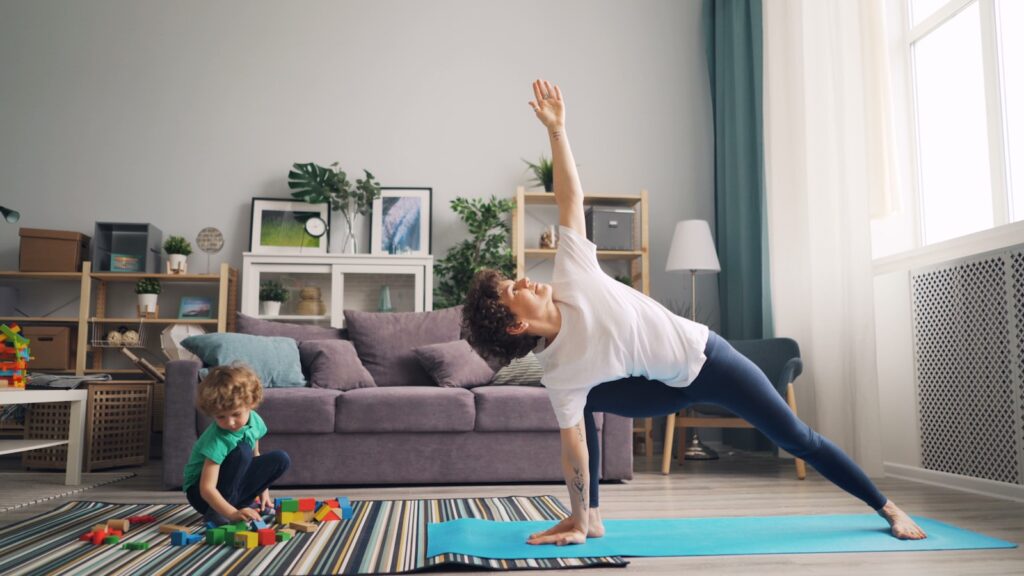 a woman and a child doing yoga in a living room
