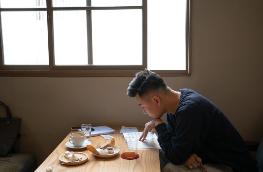 a man sitting at a table with a cup of coffee
