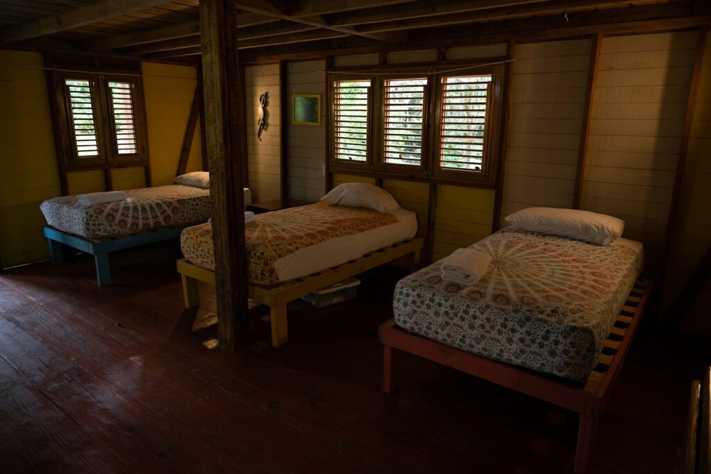 Two beds in a room with wooden floors