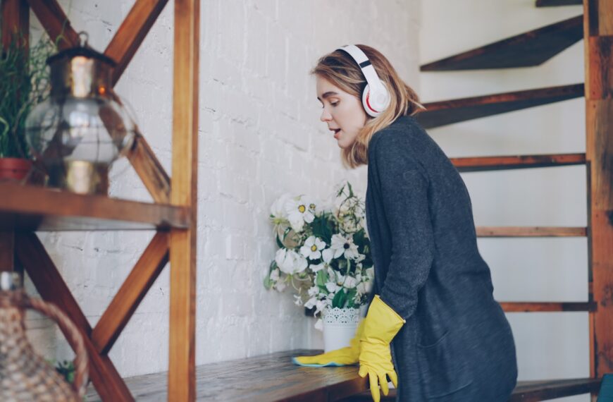 Woman cleaning while listening to music on headphones