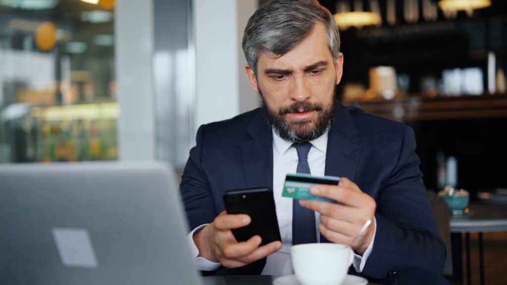 a man sitting at a table looking at his cell phone