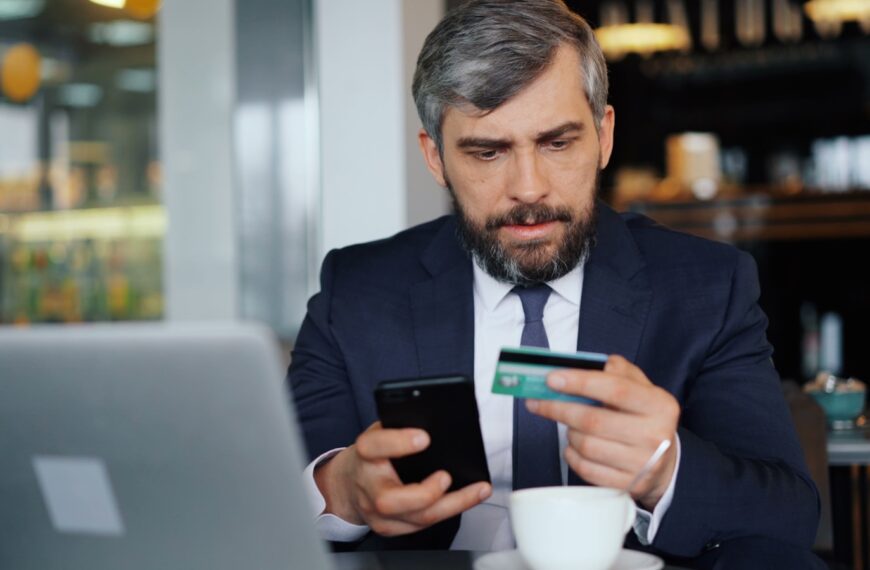 a man sitting at a table looking at his cell phone