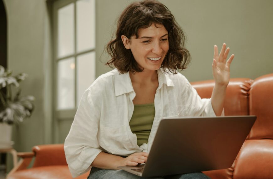 a woman sitting on a couch using a laptop computer