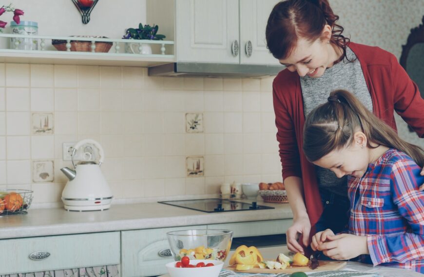 A mother and daughter cook together in the kitchen.