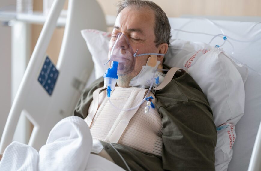a man laying in a hospital bed with oxygen in his mouth