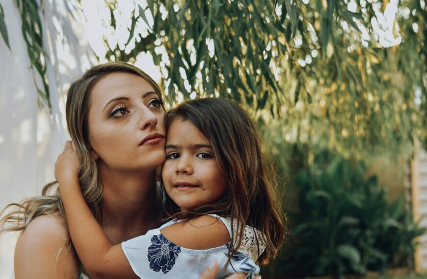 selective focus photo of woman carrying a girl