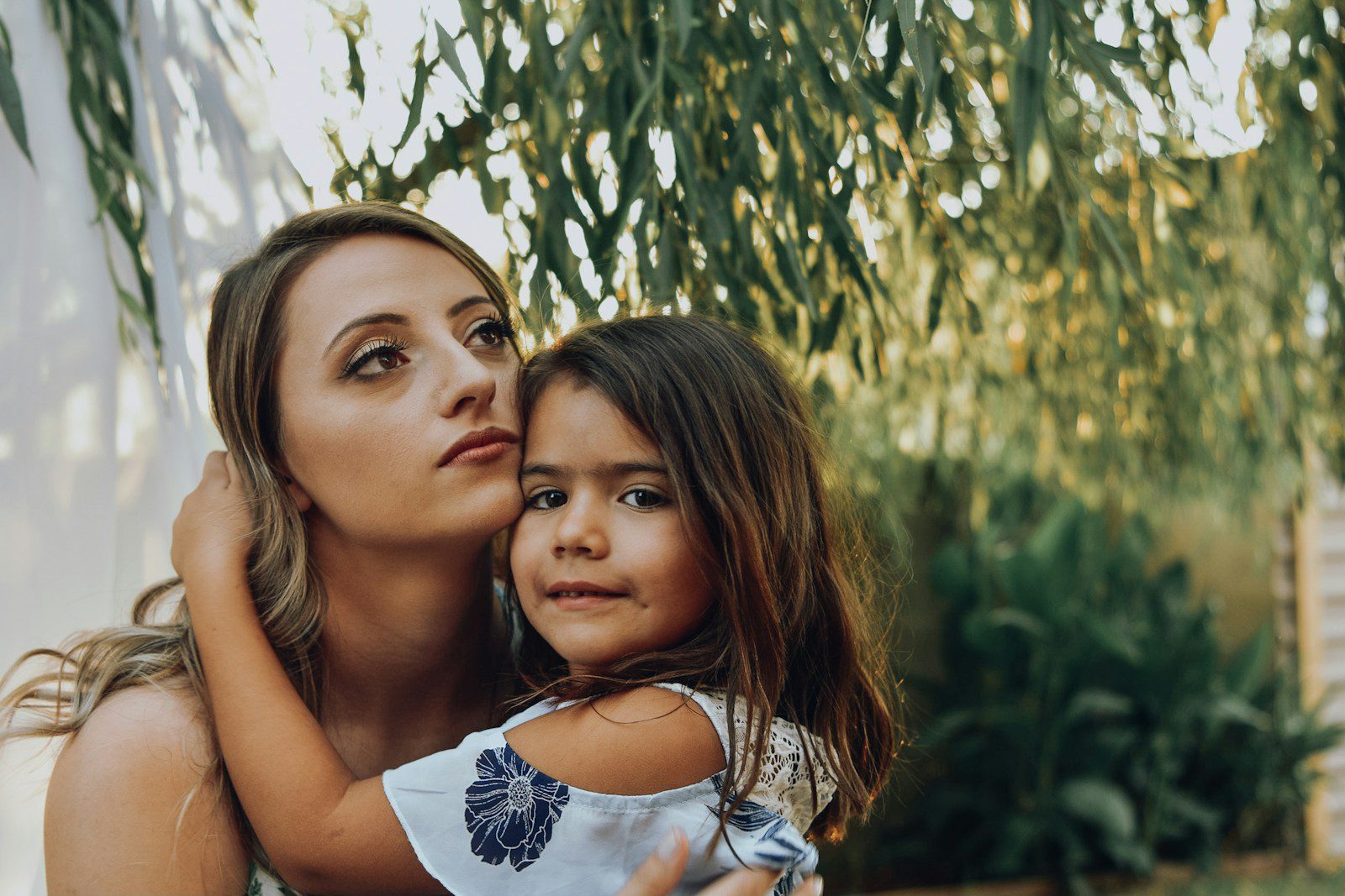 selective focus photo of woman carrying a girl