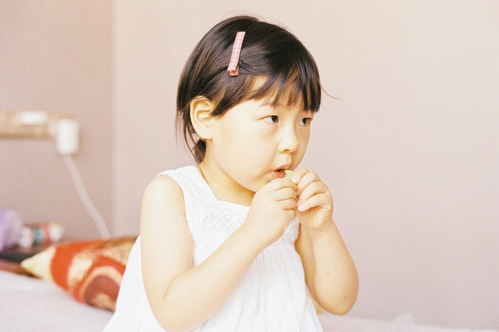 girl in white tank top eating