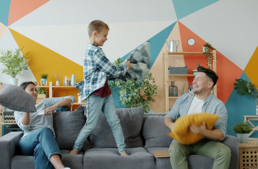 Family having a pillow fight on the couch.