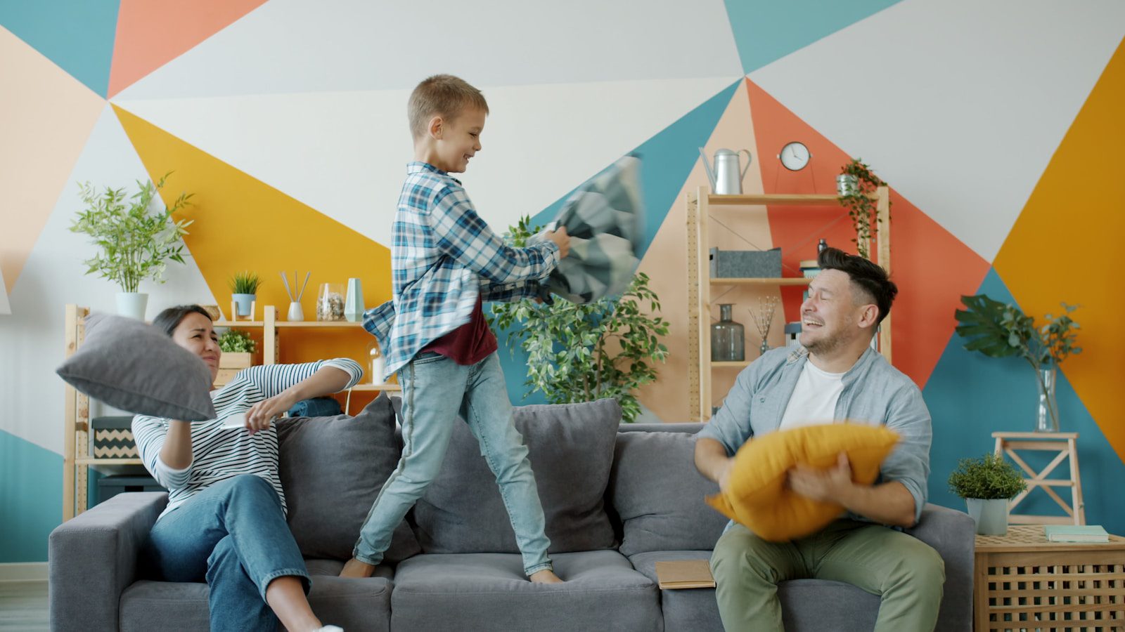 Family having a pillow fight on the couch.