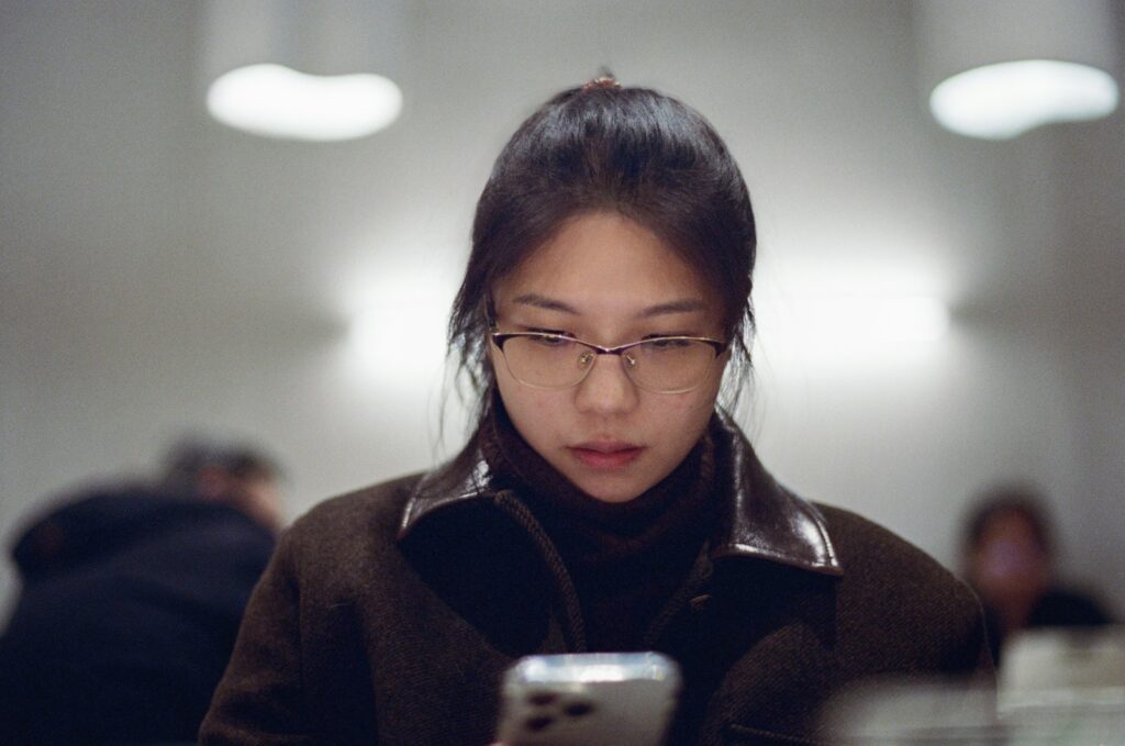 A woman looking at her cell phone in a public place