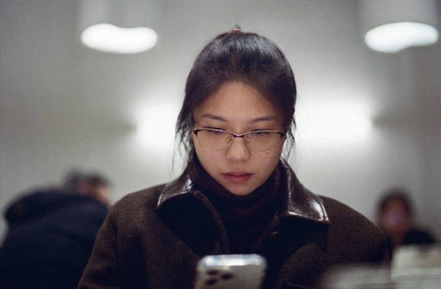 A woman looking at her cell phone in a public place