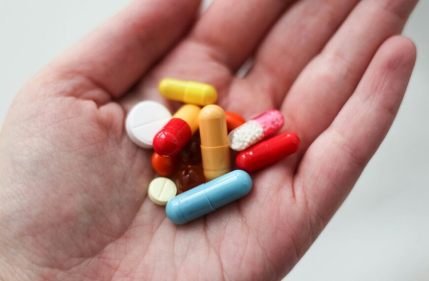 orange and white medication pill on persons hand