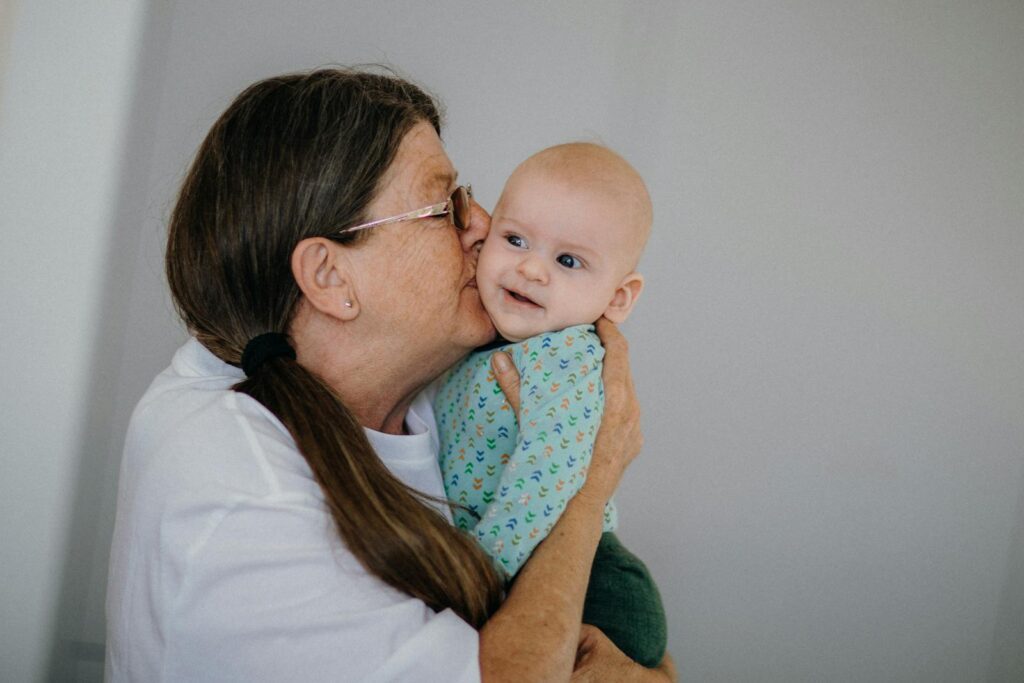 An affectionate moment between a grandmother and her smiling grandson, showcasing family love.