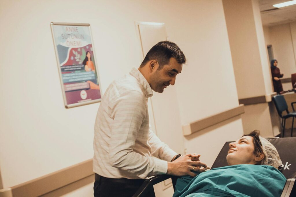 Man comforting a woman in a hospital, showcasing love and support.
