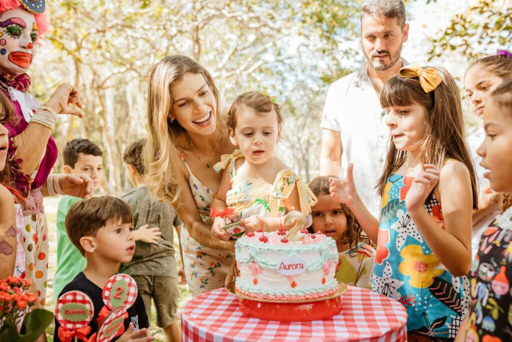 A lively outdoor children's birthday party with cake, family, and friends in a joyful atmosphere.