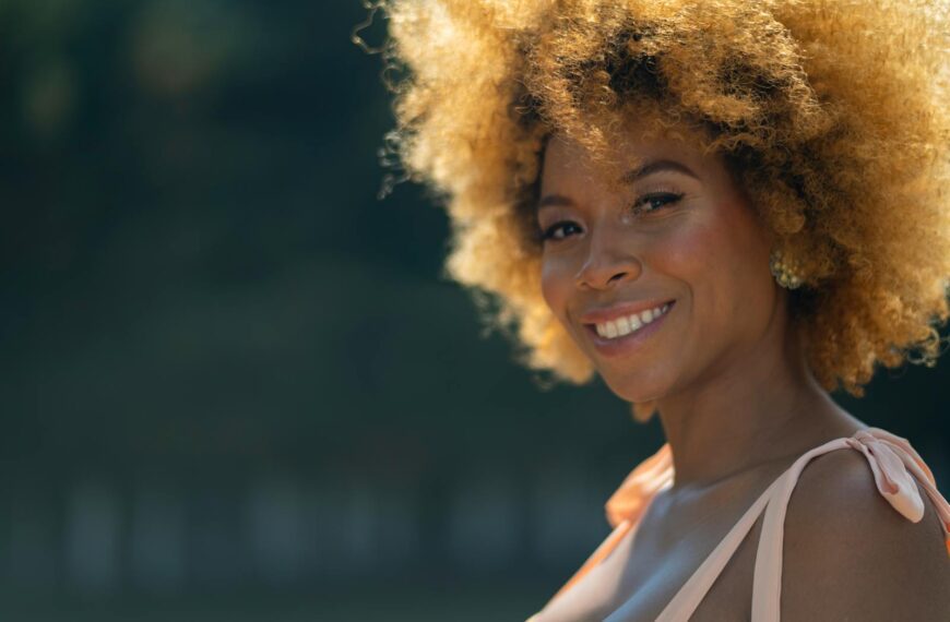 A beautiful woman with afro hair smiling outdoors in Mexico City. Warm and vibrant vibe.