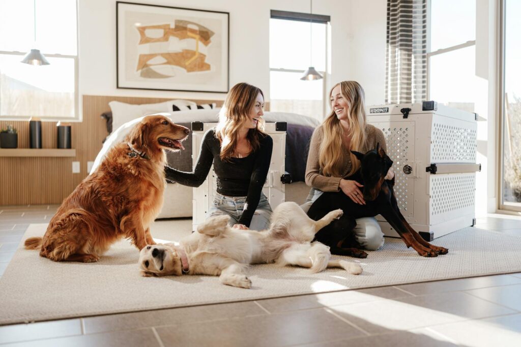 Two women with dogs enjoying a bright, modern interior space.