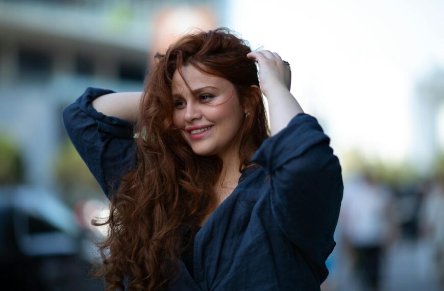 Portrait of a smiling woman with flowing hair on a sunny day in Baku, Azerbaijan.