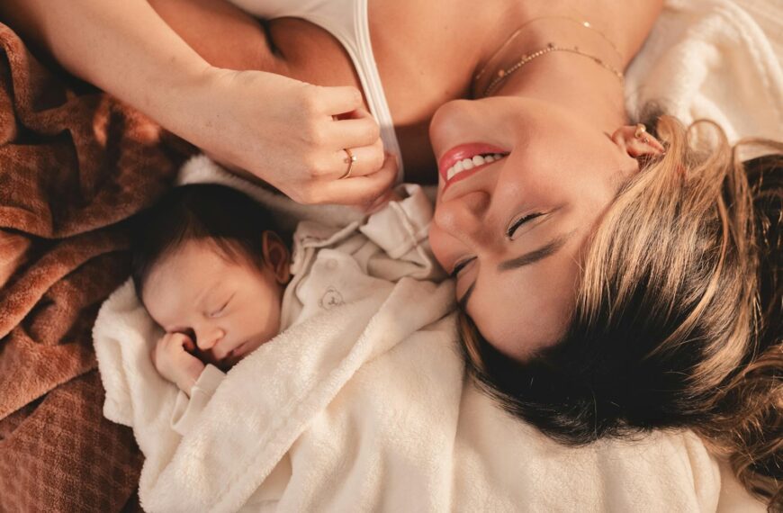 A mother and her newborn baby lying peacefully together in a cozy blanket.
