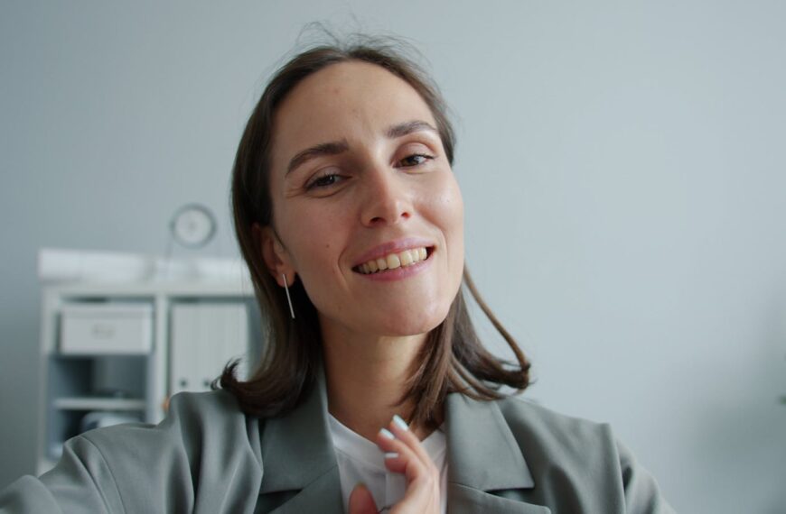 Portrait of a smiling woman in an office setting, promoting positivity.