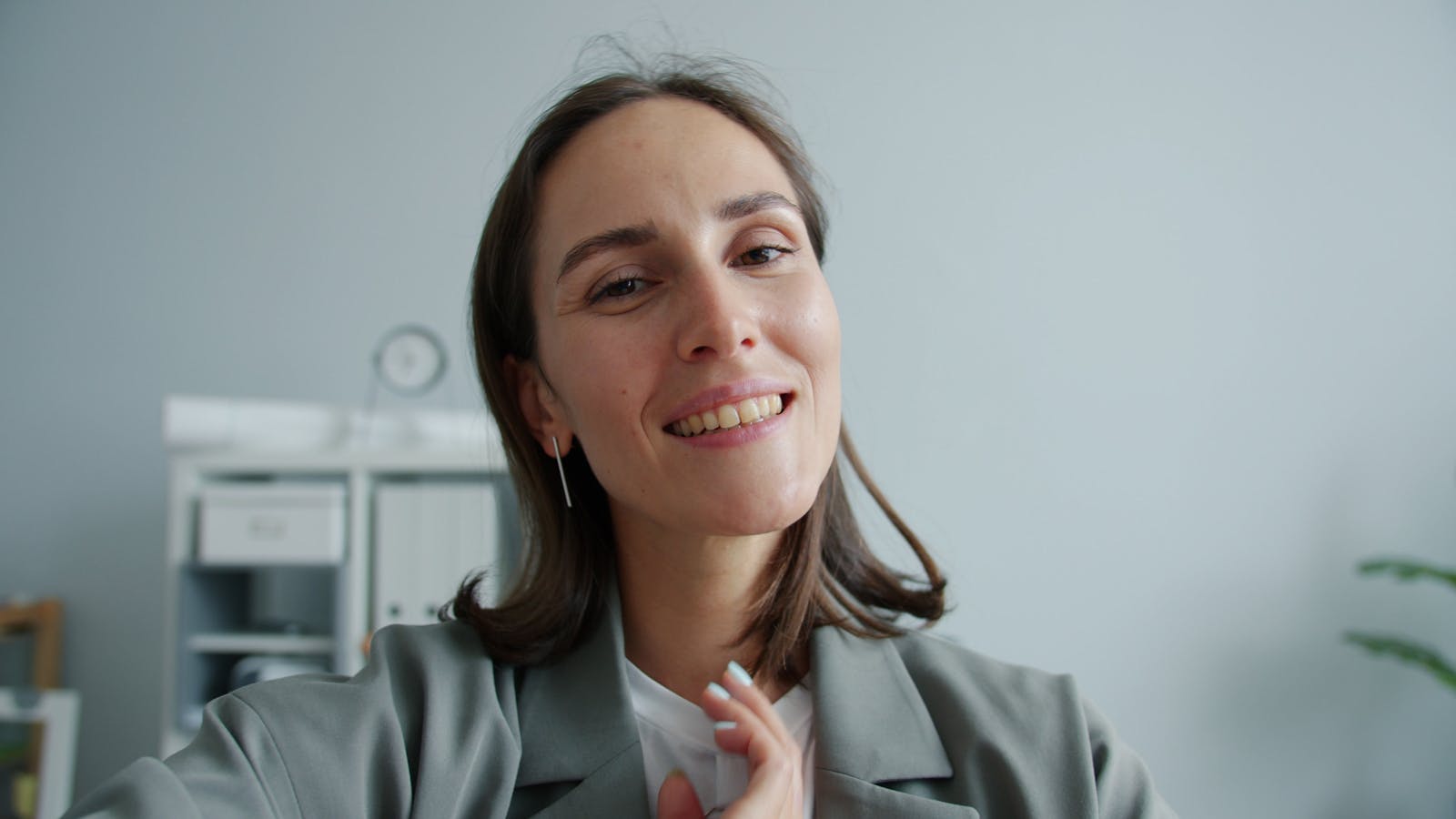 Portrait of a smiling woman in an office setting, promoting positivity.