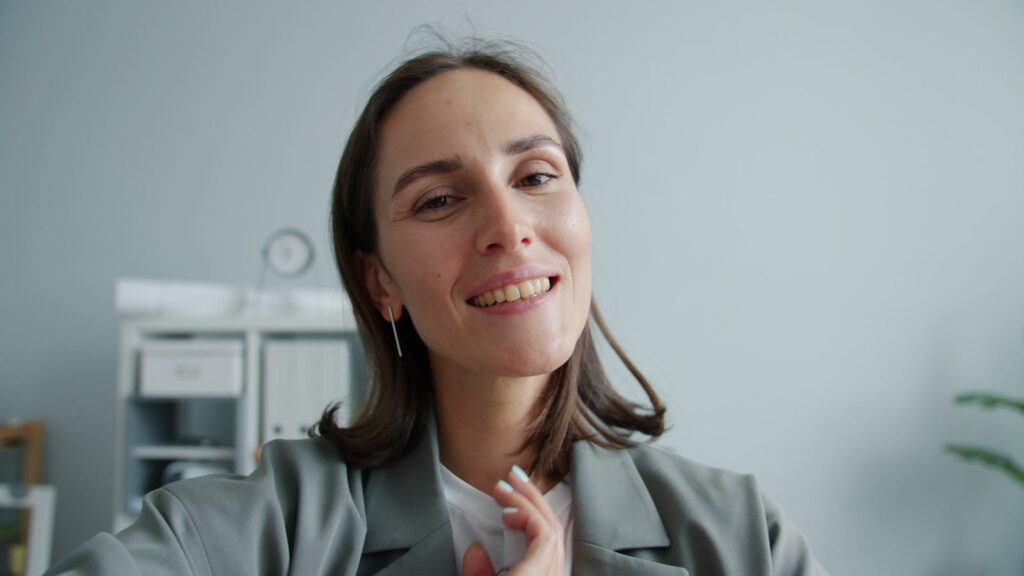 Portrait of a smiling woman in an office setting, promoting positivity.