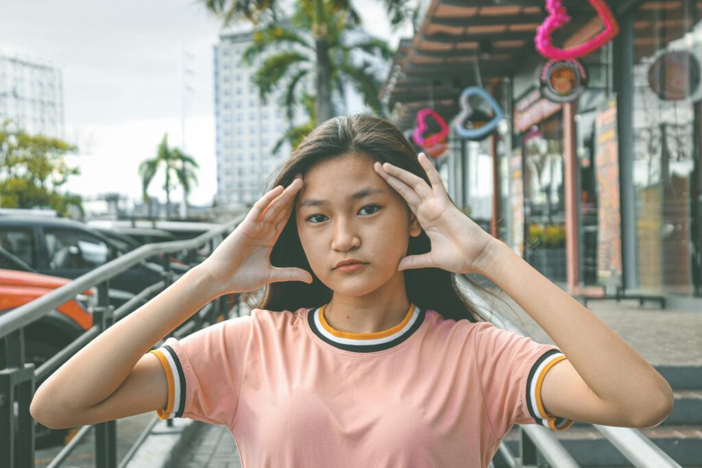 Portrait of a young woman posing with hand gestures on an urban street. Modern and casual look.
