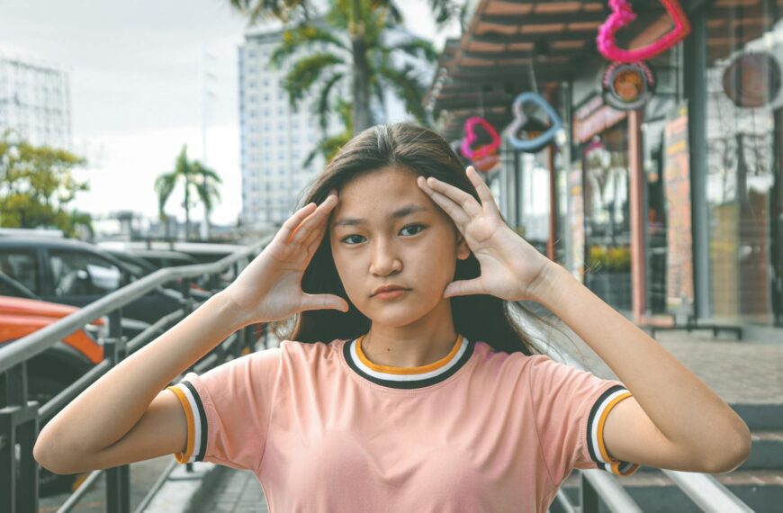 Portrait of a young woman posing with hand gestures on an urban street. Modern and casual look.