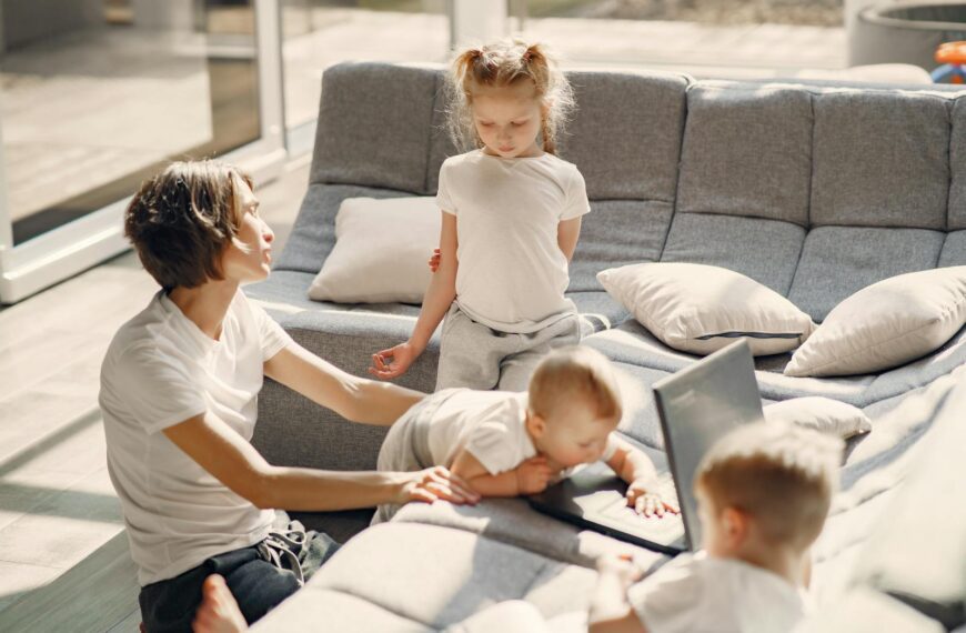 Mom and kids enjoying quality time in sunlit living room, highlighting family togetherness.